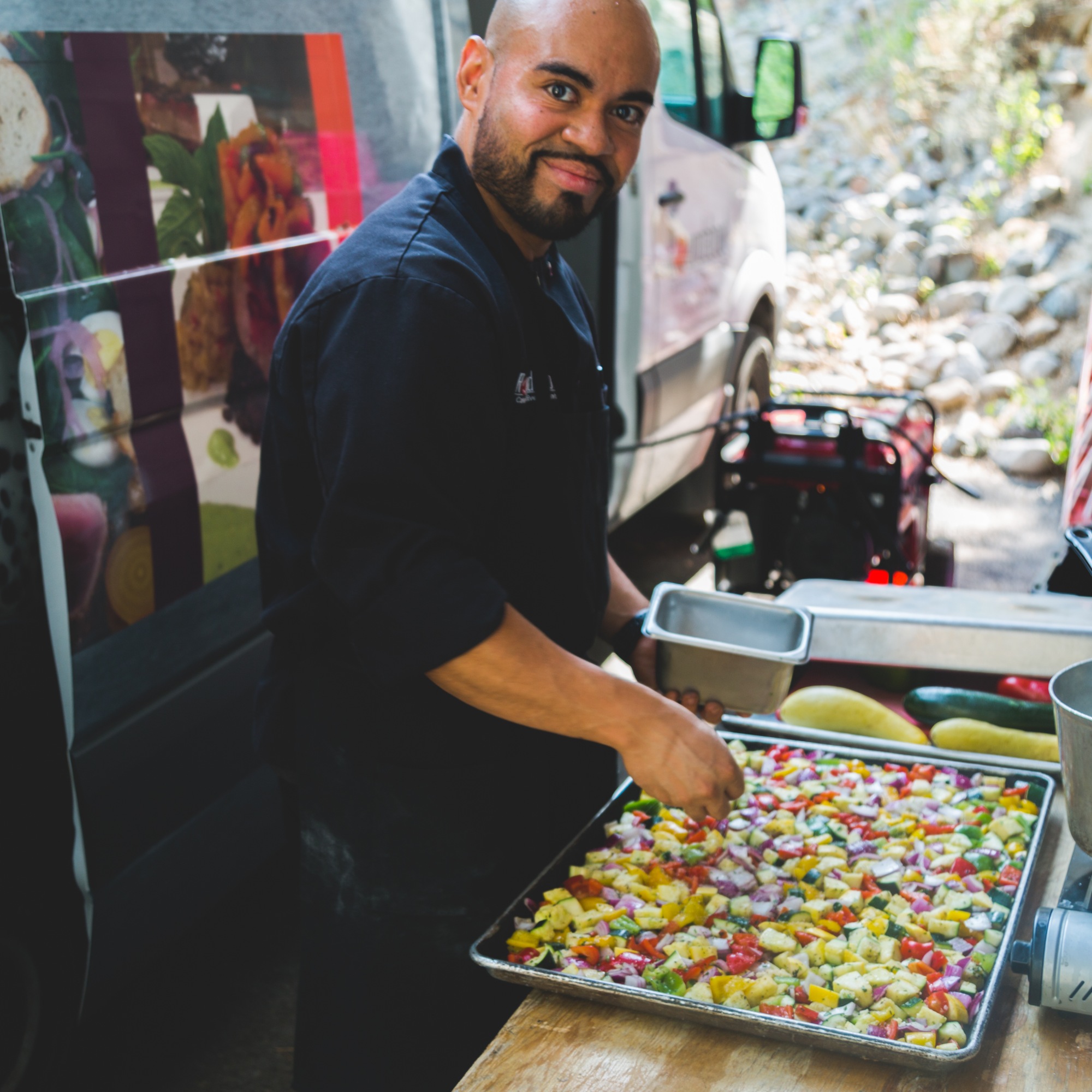 A cook preparing food beside the Roundabout catering van